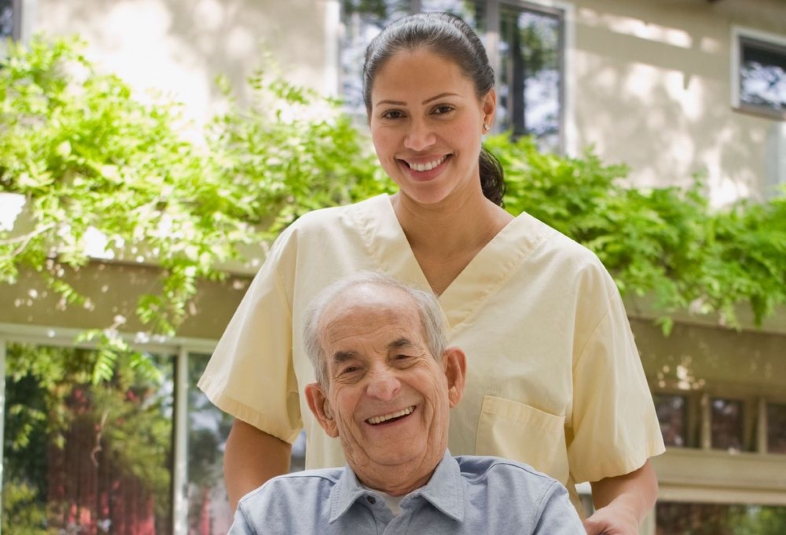 A caregiver spending time with an older man in a garden